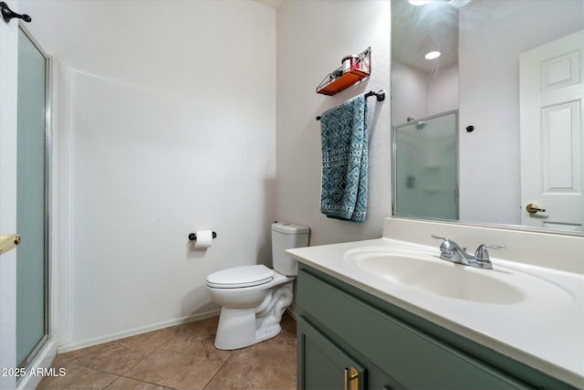 bathroom featuring toilet, a shower with shower door, vanity, baseboards, and tile patterned floors