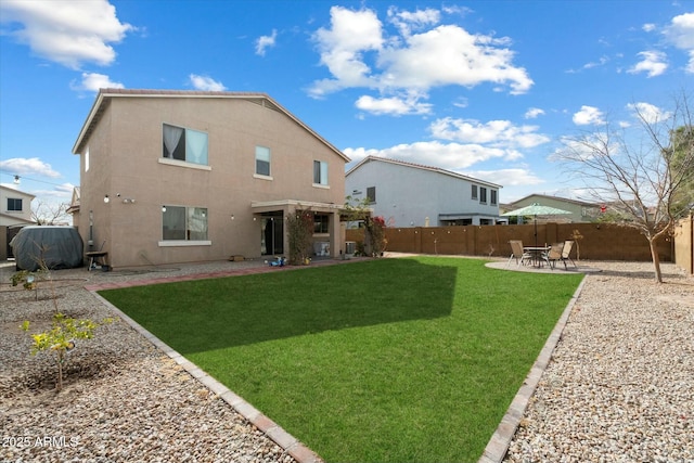 back of house featuring a patio area, a fenced backyard, a lawn, and stucco siding