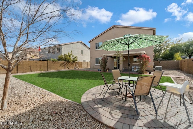 rear view of property featuring a yard, a fenced backyard, a patio, and stucco siding