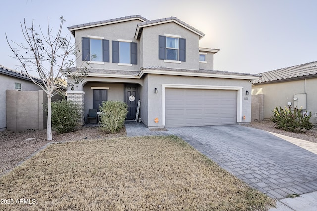 traditional home with a garage, a tile roof, decorative driveway, and stucco siding