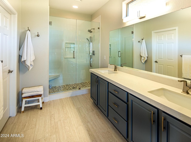 bathroom featuring a shower with door and vanity