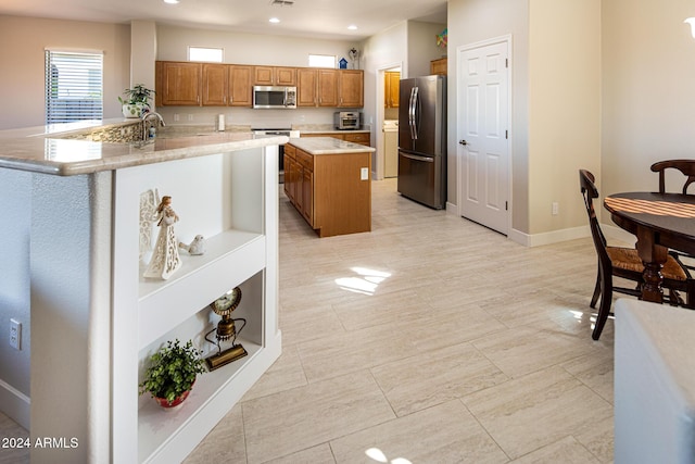 kitchen with a kitchen island, kitchen peninsula, sink, and appliances with stainless steel finishes