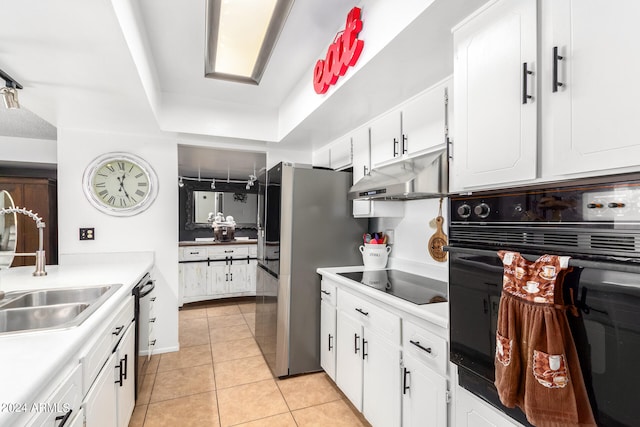 kitchen featuring light tile patterned flooring, black appliances, sink, and white cabinets