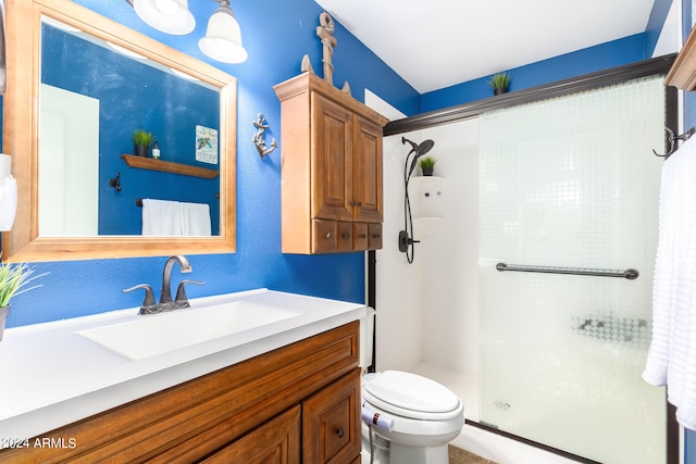 bathroom with vanity, a shower with shower door, and toilet