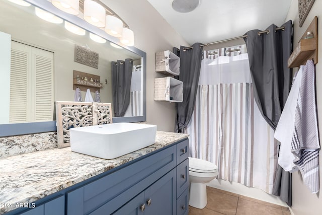 bathroom with curtained shower, tile patterned floors, vanity, and toilet