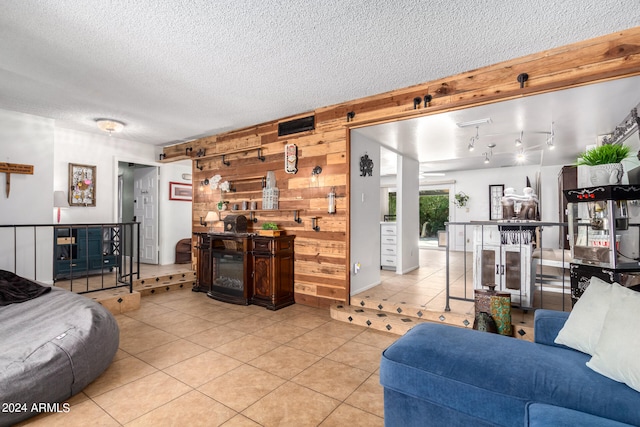 tiled living room featuring wooden walls and a textured ceiling