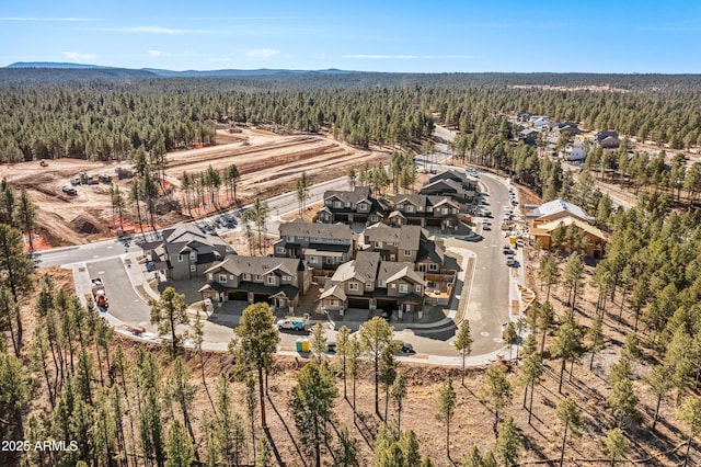 drone / aerial view featuring a residential view and a forest view