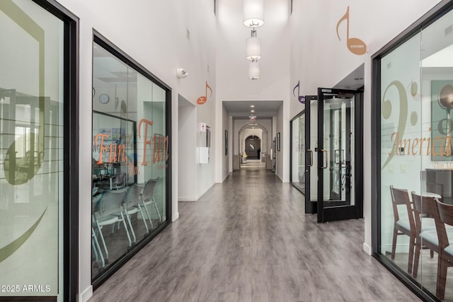 18076 W Redwood Ln, Goodyear, AZ 85338 - entryway featuring wood finished floors, baseboards, arched walkways, and a towering ceiling