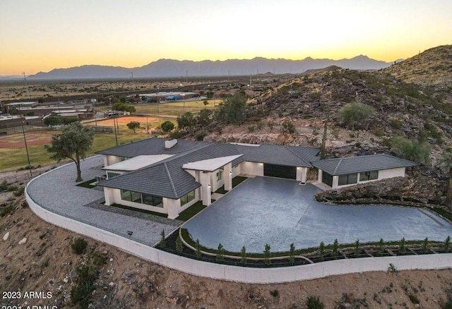 aerial view at dusk featuring a mountain view