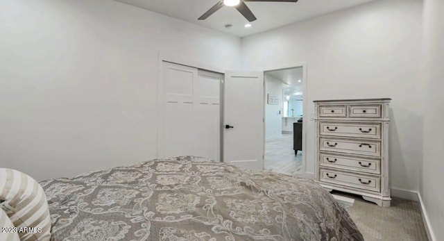 carpeted bedroom with ceiling fan and a closet