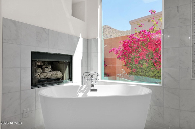 13914 E Laurel Ln, Scottsdale, AZ 85259 - bathroom featuring a fireplace, a soaking tub, and tile walls