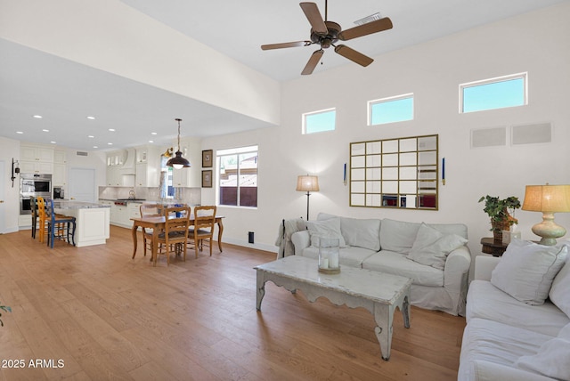 13914 E Laurel Ln, Scottsdale, AZ 85259 - living room featuring a ceiling fan, recessed lighting, a healthy amount of sunlight, and light wood-type flooring