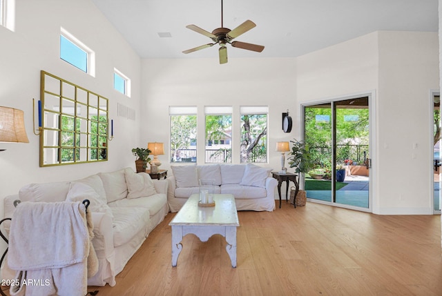 13914 E Laurel Ln, Scottsdale, AZ 85259 - living area featuring a wealth of natural light, a ceiling fan, a towering ceiling, and light wood-style flooring