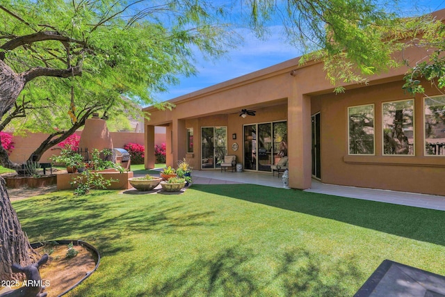13914 E Laurel Ln, Scottsdale, AZ 85259 - back of house with fence, a yard, stucco siding, ceiling fan, and a patio area
