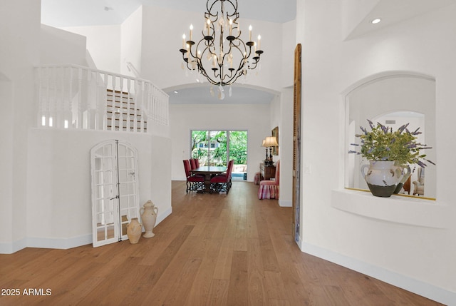 13914 E Laurel Ln, Scottsdale, AZ 85259 - corridor with french doors, baseboards, a towering ceiling, a notable chandelier, and wood finished floors