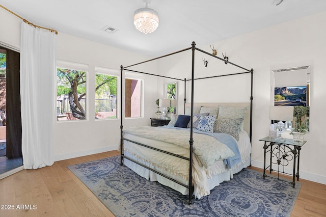 13914 E Laurel Ln, Scottsdale, AZ 85259 - bedroom featuring baseboards, a notable chandelier, wood finished floors, and visible vents