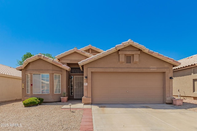 ranch-style house featuring stucco siding, driveway, a tile roof, and a garage