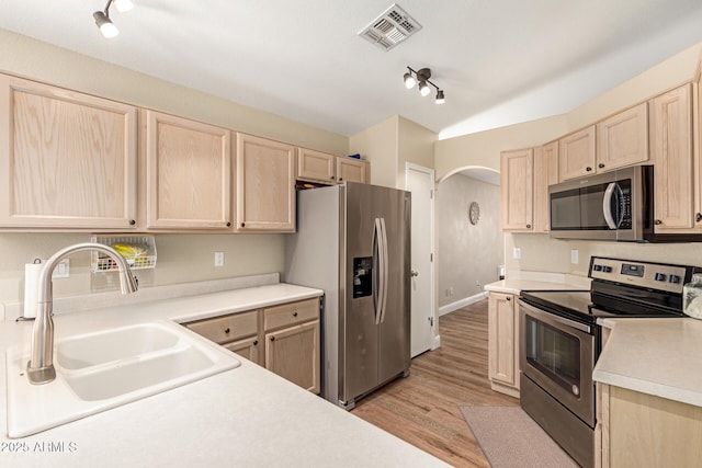 kitchen with visible vents, track lighting, light brown cabinets, a sink, and appliances with stainless steel finishes