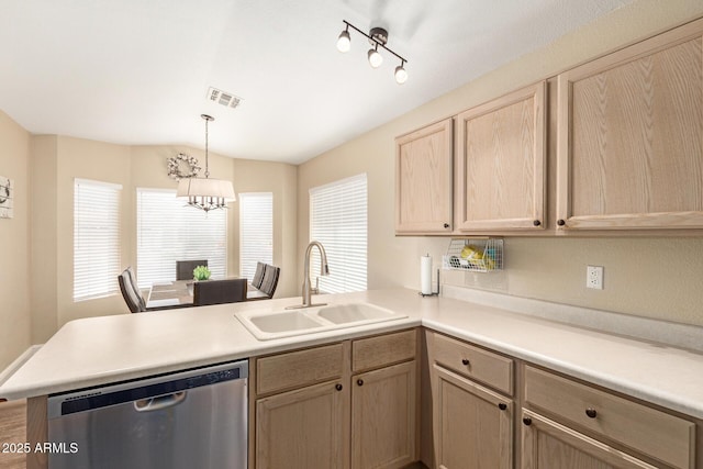 kitchen featuring light brown cabinetry, stainless steel dishwasher, a sink, light countertops, and a peninsula