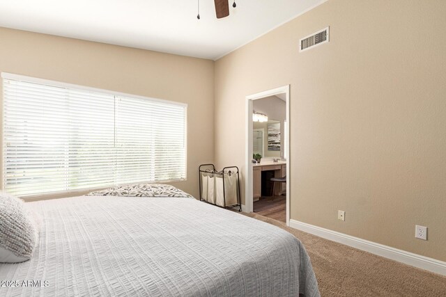 carpeted bedroom with baseboards, a ceiling fan, connected bathroom, and visible vents