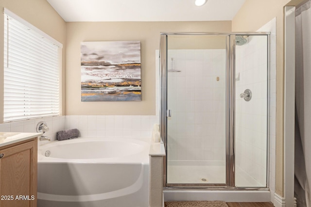 full bathroom with vanity, a garden tub, and a stall shower