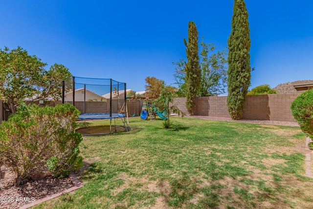 view of yard with a playground, a fenced backyard, and a trampoline