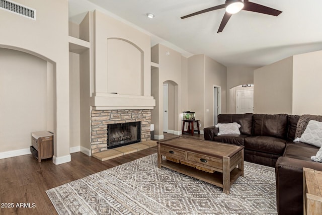 living room featuring visible vents, wood finished floors, baseboards, ceiling fan, and arched walkways