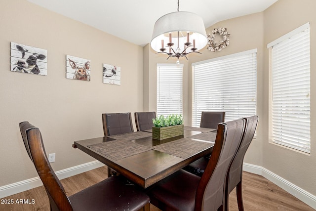 dining room featuring baseboards, a chandelier, a wealth of natural light, and light wood finished floors
