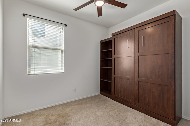 unfurnished bedroom featuring ceiling fan and light colored carpet