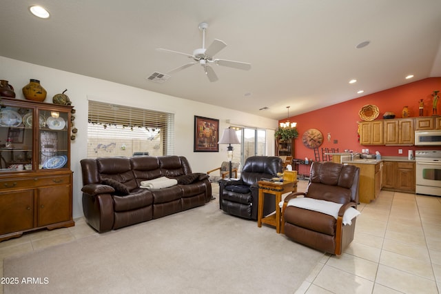 living room featuring lofted ceiling, light tile patterned floors, ceiling fan with notable chandelier, and a wealth of natural light