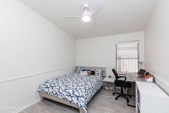 bedroom featuring light wood-style flooring, baseboards, a ceiling fan, and lofted ceiling