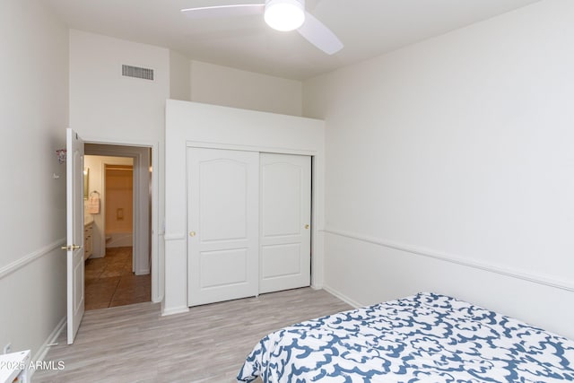 bedroom featuring visible vents, a closet, baseboards, ceiling fan, and light wood-style flooring