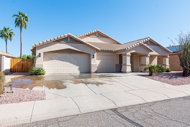 mediterranean / spanish-style house with a tiled roof, an attached garage, driveway, and stucco siding