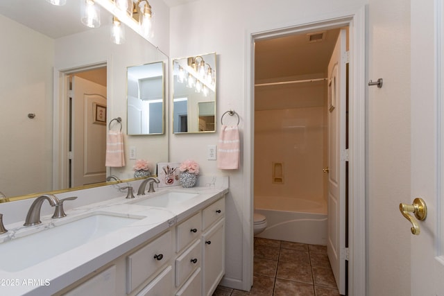 full bath featuring toilet, double vanity, a sink, and visible vents