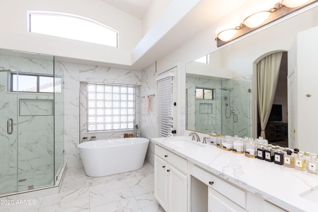 full bath with a freestanding tub, plenty of natural light, marble finish floor, and a marble finish shower