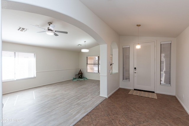 foyer with visible vents, arched walkways, ceiling fan, vaulted ceiling, and tile patterned floors