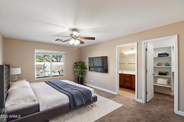 2487 S Conestoga Rd, Apache Junction, AZ 85119 - bedroom with light carpet, ensuite bathroom, a ceiling fan, and a walk in closet