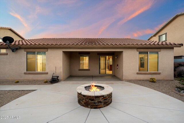 2487 S Conestoga Rd, Apache Junction, AZ 85119 - back of property at dusk featuring a fire pit, stucco siding, a patio, and a tiled roof