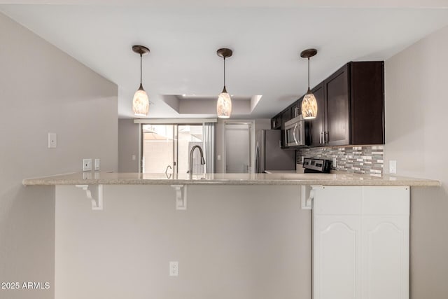 19601 N 7th St Unit 1022, Phoenix, AZ 85024 - kitchen featuring stainless steel appliances, dark brown cabinetry, a peninsula, and a kitchen bar