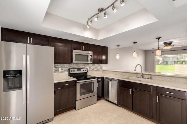 19601 N 7th St Unit 1022, Phoenix, AZ 85024 - kitchen with appliances with stainless steel finishes, a tray ceiling, dark brown cabinetry, light tile patterned floors, and tasteful backsplash