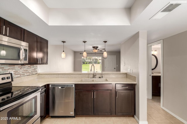 19601 N 7th St Unit 1022, Phoenix, AZ 85024 - kitchen featuring stainless steel appliances, dark brown cabinets, light countertops, light tile patterned flooring, and decorative backsplash