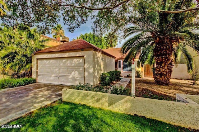 view of front of home featuring an attached garage, concrete driveway, and stucco siding