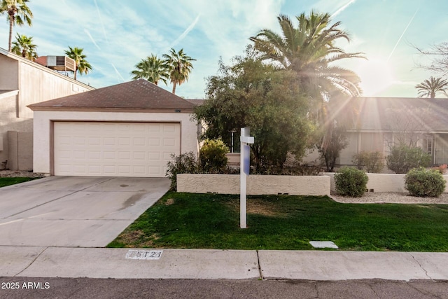 view of front facade featuring a garage, a front lawn, concrete driveway, and stucco siding