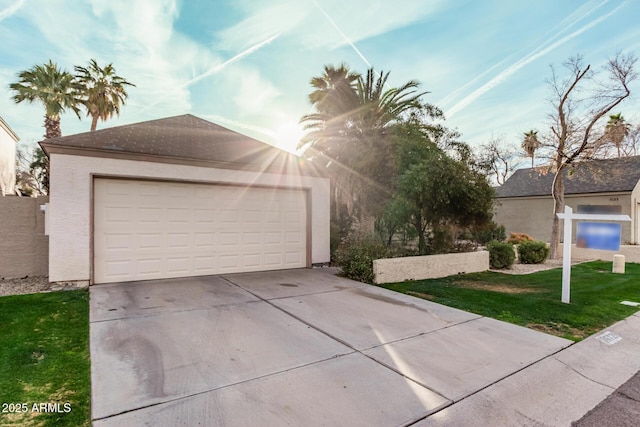 view of front facade with a garage, an outbuilding, a front lawn, and stucco siding