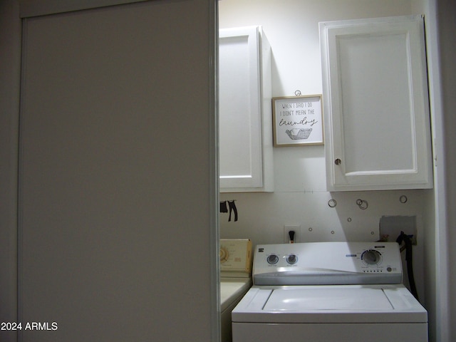 laundry room with separate washer and dryer and cabinets