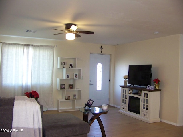 living room with light hardwood / wood-style floors and ceiling fan