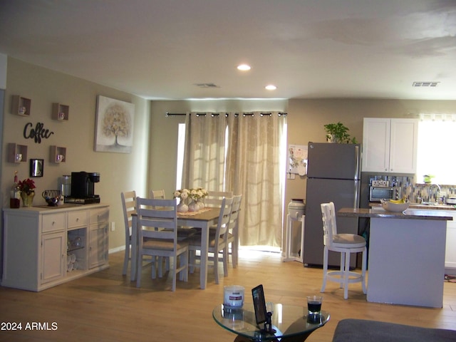 dining area with sink and light hardwood / wood-style flooring