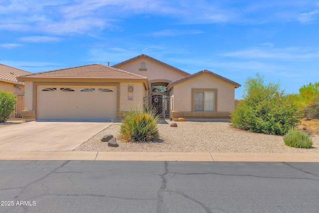 4611 E Night Glow Dr, Cave Creek, AZ 85331 - mediterranean / spanish-style house featuring stucco siding, a garage, concrete driveway, a tile roof, and a gate