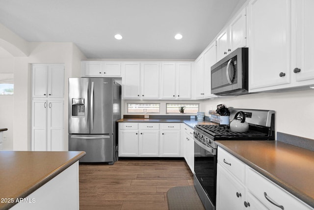 4611 E Night Glow Dr, Cave Creek, AZ 85331 - kitchen with stainless steel appliances, dark countertops, white cabinets, dark wood-style flooring, and recessed lighting