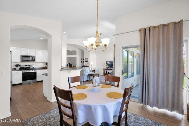 4611 E Night Glow Dr, Cave Creek, AZ 85331 - dining space with arched walkways, dark wood-style flooring, a chandelier, and recessed lighting